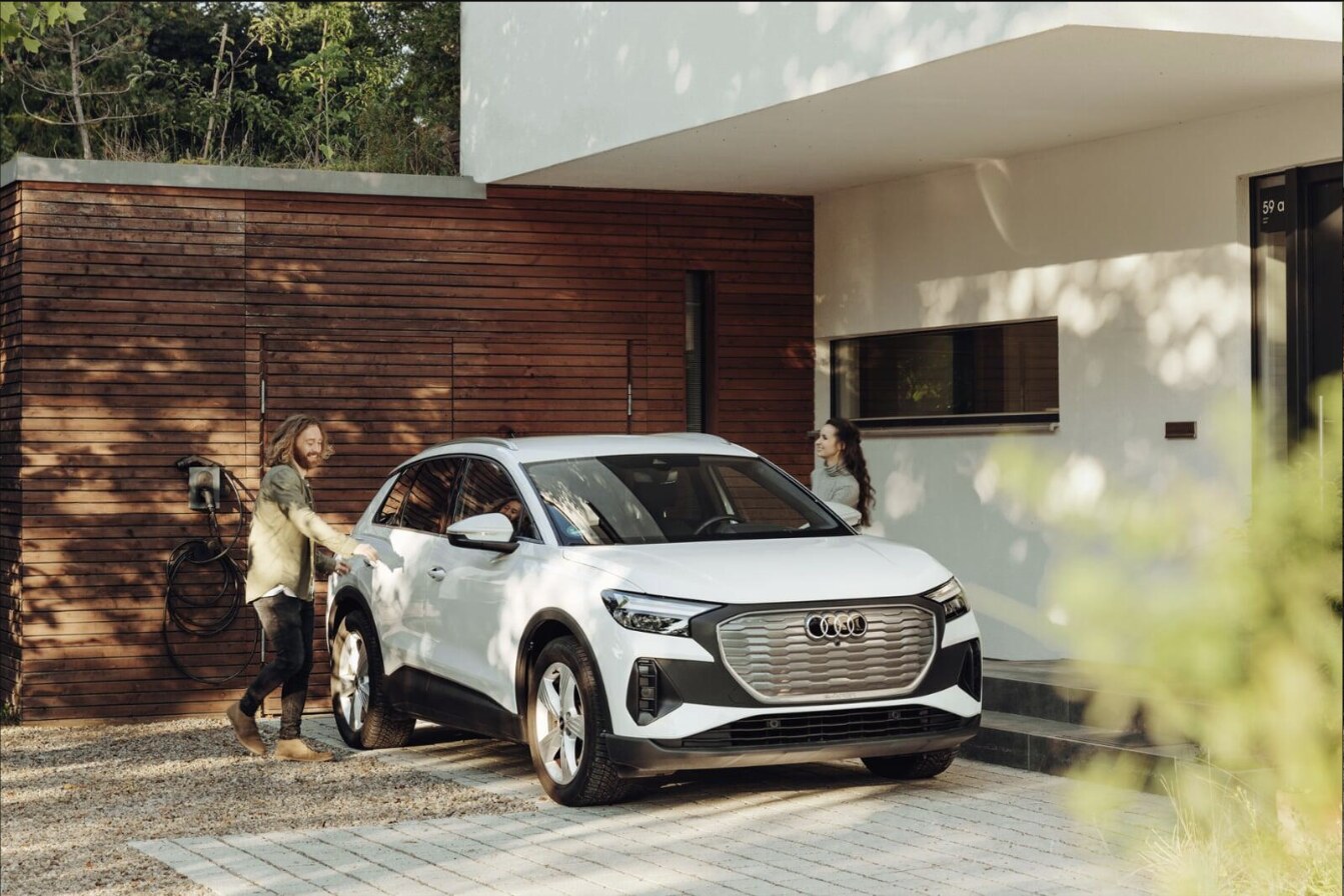 Couple at home with their EV charging from a wall charger