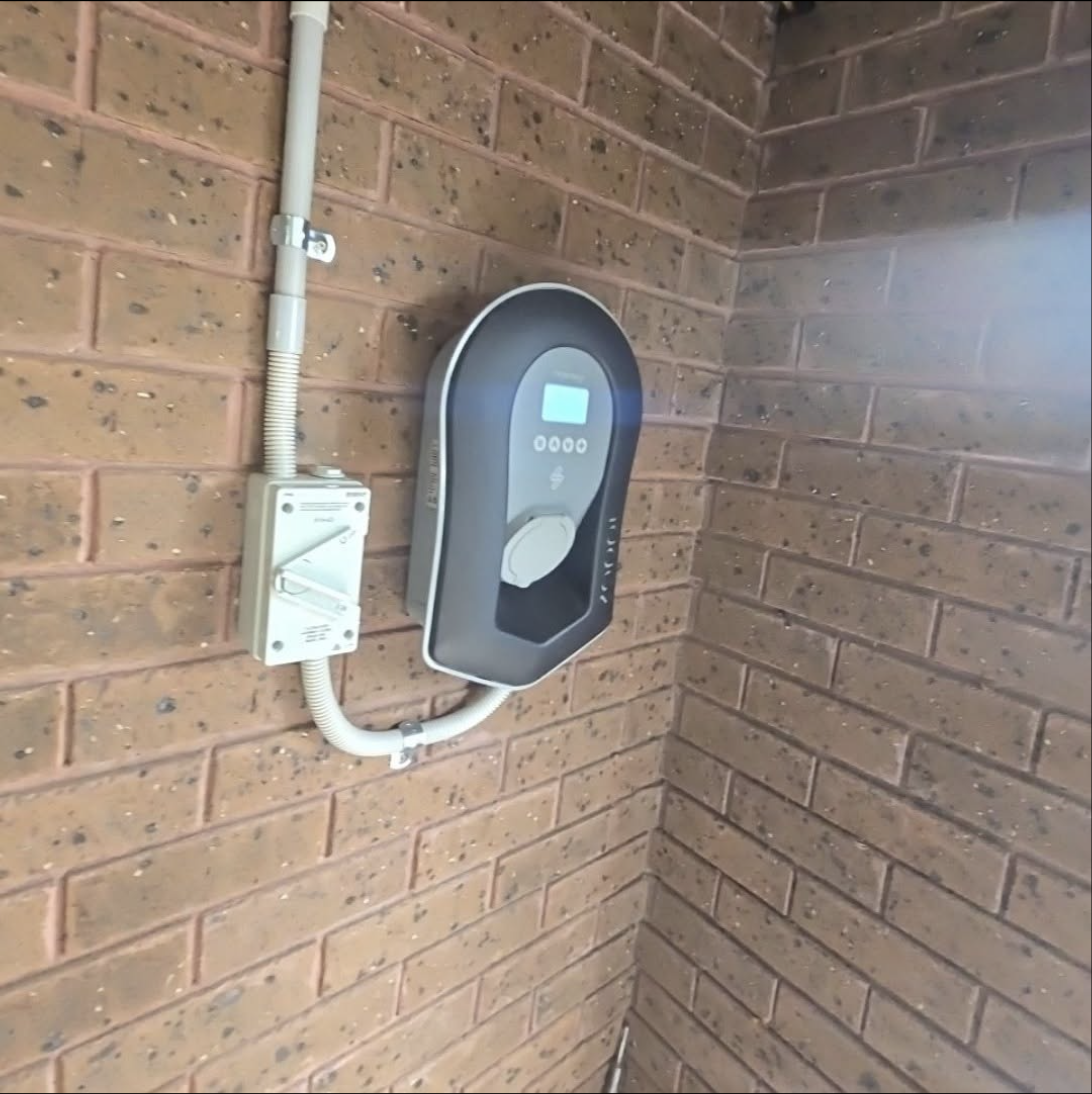 myenergi Zappi charger installed on a brick wall